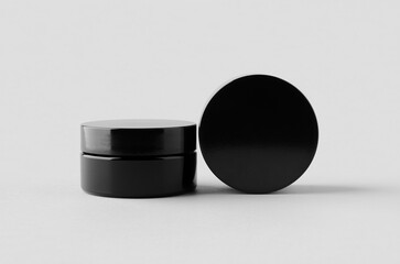 Sticker - Black glass cream jar packaging mockup.