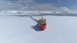 Icebreaker vessel navigating Antarctic waters - breaks through pack ice on its way. Aerial view. Featuring red color Laurence M. Gould Research Boat slicing through the Southern Ocean's ice expanse