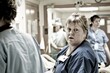 © Konstiantyn Zap - A woman in scrubs stands confidently in a hospital setting, embodying dedication and care in her role as a nurse