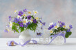 Still life with spring flowers blue hepatica and white anemones in a vase, bicycle decor. Beautiful card.