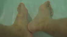 Bare Human Feet In Greenish Water, Possibly In A Bathtub, With A Simplistic And Serene Vibe.