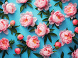 Pink peony flowers and green leaves intertwine to create a floral pattern on a blue background