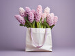 Pink, white, and violet hyacinths peek from a shopping bag