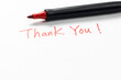 Hand written thank you message with a red pen on white background, gratitude concept.