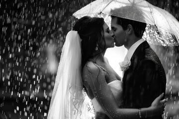 Wall Mural - Romantic Black and White Portrait of Newlyweds Kissing in the Rain