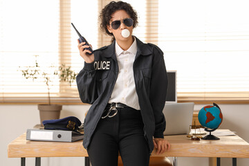 Sticker - African-American police officer with radio transmitter blowing bubble gum in office