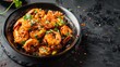 Schezwan Prawns are presented in a black bowl against a dark slate background, highlighting an Indo-Chinese cuisine curry dish flavored with Schezwan sauce