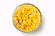Corn seeds in a glass bowl on white background. Top view