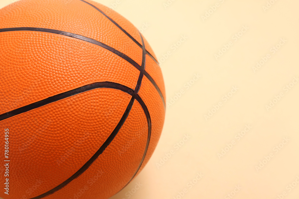 Ball for playing basketball on orange background, closeup