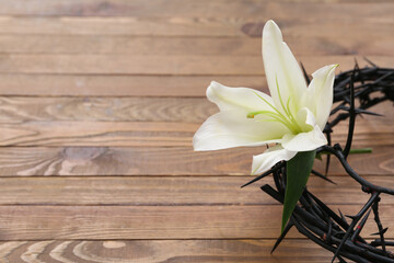 Wall Mural - Crown of thorns with white lily on wooden background