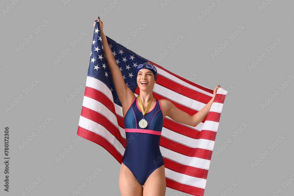 Female swimmer with first place medal and USA flag on light background