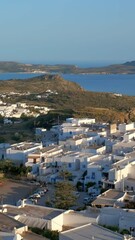 Wall Mural - Panoramic view of Plaka village with traditional Greek church and ocean coast. Milos island, Greece. Camera pan