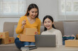 Two business owners are checking customer information on a package before it is delivered to the buyer, Two co-workers are checking that order data matches sales figures.