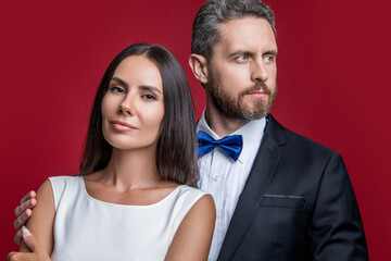 Anniversary portrait. Valentines day occasion. Formal couple. Couple in formal wear. Man and woman in luxury suit. Elegant style date. Romantic woman with elegant man isolated on red. Couple in love