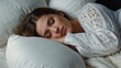 © VistaVisions - Top view of attractive beautiful young woman sleeping well in bed hugging soft white pillow, teenage girl resting, good night sleep concept. Lady enjoys fresh soft bedding linen and mattress in bedroo
