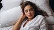 © VistaVisions - Top view of attractive beautiful young woman sleeping well in bed hugging soft white pillow, teenage girl resting, good night sleep concept. Lady enjoys fresh soft bedding linen and mattress in bedroo