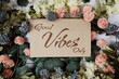 Good Vibes only text message on paper card with flowers border frame on wooden background