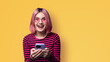 Excited surprised shocked astonished very happy pink funny woman wear braces sunglasses eye glass spectacles open mouth hold typing cell phone cellular smartphone cellphone isolated yellow background.