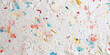 background with splashes paint,colorful wall texture ,white watercolor paper with colorful sprinkles, flat lay,