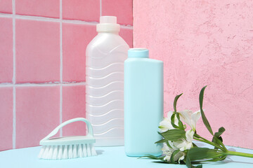 Wall Mural - Detergents with fresh flowers on a pink background