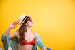 Stylish Latina Woman in Sun Hat Looking Away on Yellow Background