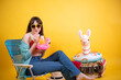 Young Latina Woman with Summer Pool Toys on Yellow Background