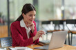 © crizzystudio - Businesswoman working with online data on laptop and folders Stack of documents to analyze, plan, and calculate financial statistics, and taxes at a desk in a modern office.
