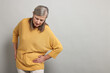 © New Africa - Arthritis symptoms. Woman suffering from hip joint pain on gray background, space for text