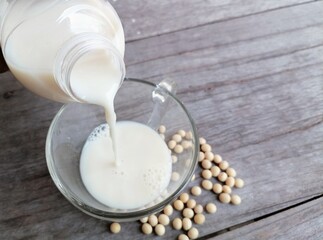 Canvas Print - Pouring soy milk with soybean on wood background