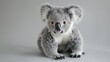 Close-up of a fluffy koala toy with plush gray fur and adorable animal features sitting isolated in a studio