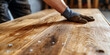 A person wearing gloves is working on the wooden floor,man installing wooden floor