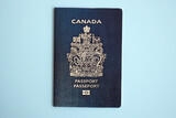 Fototapeta  - Canadian passport on blue background close up. Tourism and citizenship concept