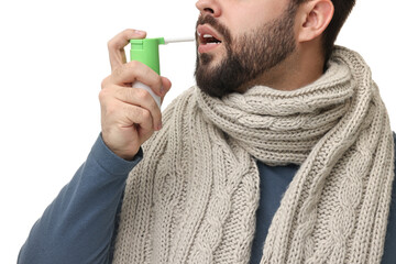 Sticker - Young man with scarf using throat spray on white background, closeup