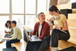 © LIGHTFIELD STUDIOS - Multicultural students, including an African American girl, sitting together on wooden floor, engaged in education discussion