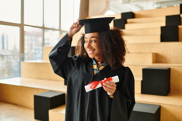 A young African American woman stands proudly in a graduation cap and gown, symbolizing academic success and accomplishments.