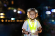 © famveldman - Safety on dark street. Kids reflective vest.