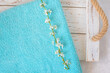 cherry blossom branch and turquoise towel on a white wooden background. spa and freshness atmosphere