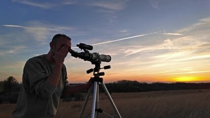 Wall Mural - amateur astronomer observing solar eclipse and sun with a telescope and special solar filter.