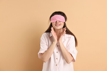 Wall Mural - Woman in pyjama and sleep mask on beige background