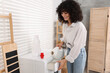 © New Africa - Woman pouring laundry detergent into washing machine indoors