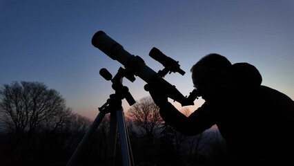 Wall Mural - amateur astronomer looking at the evening skies, observing planets, stars, moon and other celestial 
