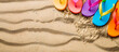 Colorful beach flip flops on the sand. Summer holidays and travel banner with copy space.