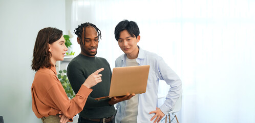 Poster - Multinational people talking while looking at laptop PC in the lobby. International business.