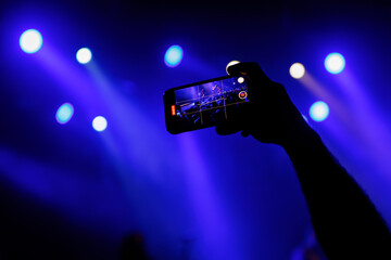 Wall Mural - Making photo with smartphone during a concert to share the moment with friends on social networks.