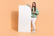 © deagreez - Full length body size view of beautiful trendy cheerful girl demonstrating copy space isolated over beige pastel color background