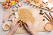 Woman making Christmas cookies with cutters at white wooden table, top view