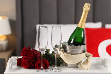 Sticker - Honeymoon. Sparkling wine, glasses and bouquet of roses on table in room