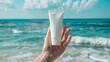 © Michela - Mano di donna mostra crema per il corpo. Sfondo con mare