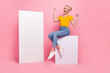 Full size photo of hooray blond lady sit yell near promo wear t-shirt jeans shoes isolated on pink background