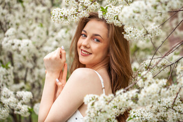 Young beautiful woman in a blooming garden